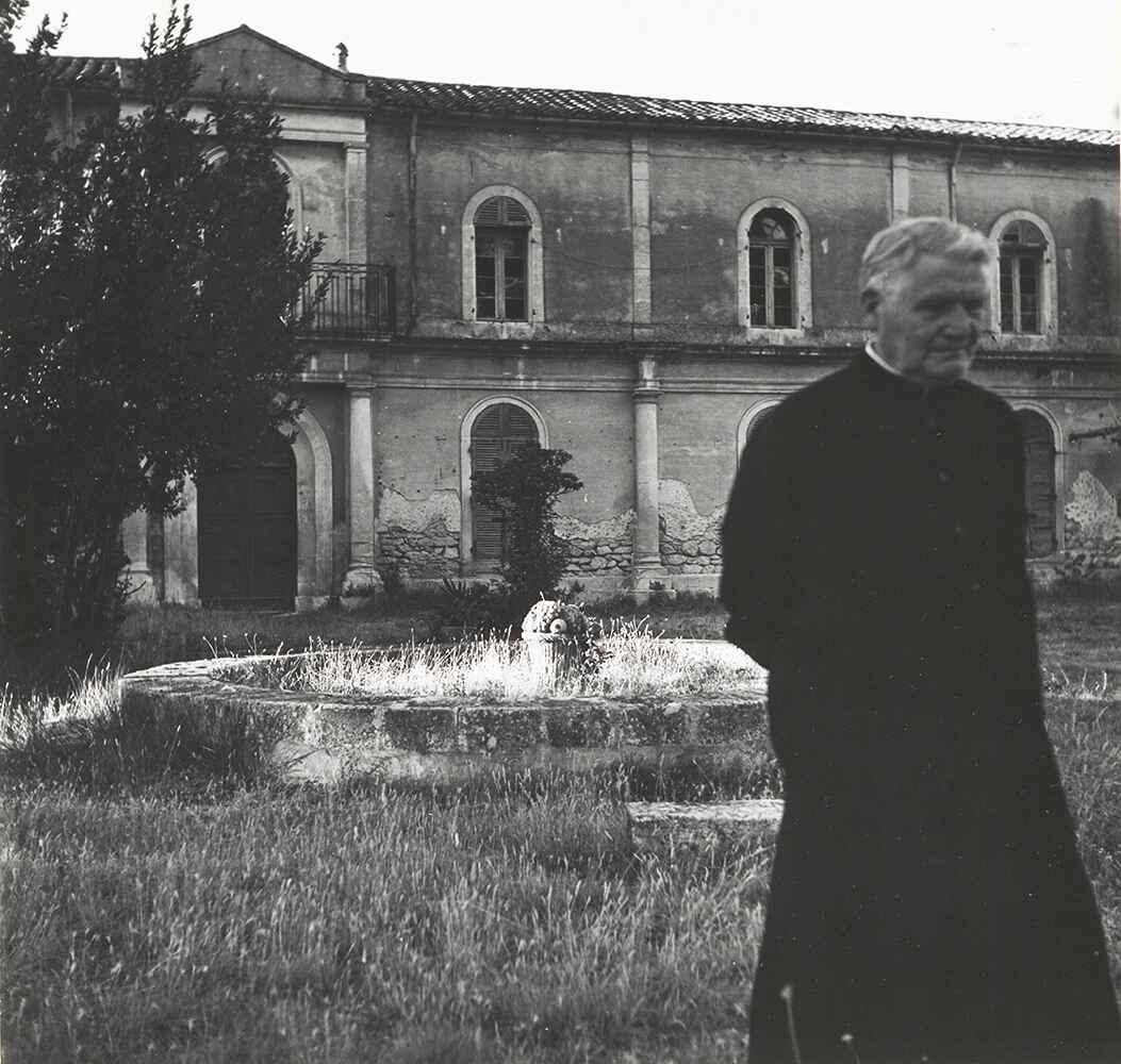 Clergyman and old fountain in the garden of the monastery Saint-Paul Asylum
